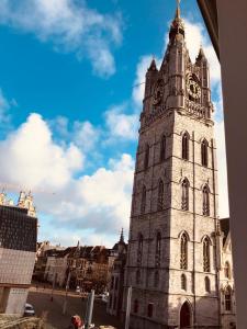 Una torre alta con un reloj encima. en Evelyns Corner Duplex en Ghent