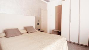 a bedroom with a white bed with two pillows on it at Hotel Aria di Mare Bed & Breakfast & Beach in centro a Riccione in Riccione