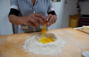 a person is making a sauce on a wooden surface at Agriturismo Mocine in Asciano