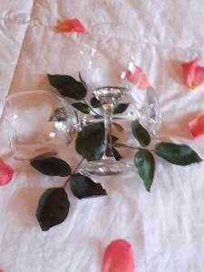 a wine glass sitting on a bed with flowers at Pousada rio canoas in Urubici