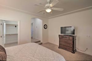 a bedroom with a bed and a flat screen tv at Desert Condo with Pool about 3 Miles to Colorado River! in Bullhead City