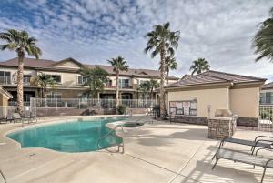 a swimming pool with palm trees and a building at Desert Condo with Pool about 3 Miles to Colorado River! in Bullhead City