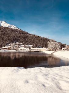 un cuerpo de agua con nieve en el suelo en Studio in Klosters, en Klosters