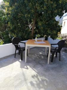 een houten tafel en twee stoelen zittend onder een boom bij Casa Lita in Hermigua