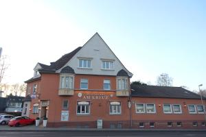 ein großes rotes Backsteingebäude mit grauem Dach in der Unterkunft Gasthof & Restaurant "Am Kreuz" in Essen