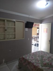 Camping Clube e Pousada Novilha de Ouro في كالدس نوفاس: غرفة نوم فيها سرير وتلفزيون