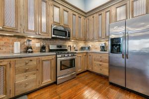 una cocina con armarios de madera y electrodomésticos de acero inoxidable en Cozy and Charming House Close to St Charles Ave, en Nueva Orleans