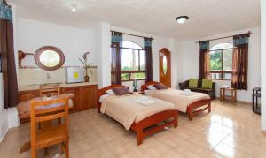 1 Schlafzimmer mit 2 Betten, einem Tisch und einem Stuhl in der Unterkunft Hotel Twin Galápagos in Puerto Ayora