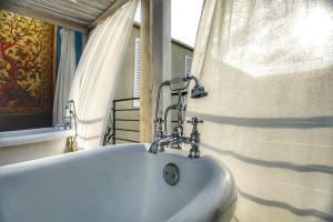 a white bath tub in a bathroom with a window at La Casa del Atrio in Querétaro