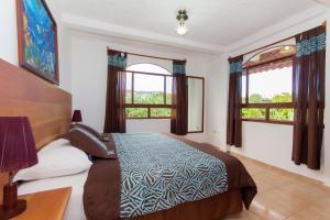 a bedroom with a bed and two windows at Hotel Twin Galápagos in Puerto Ayora