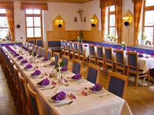 a long table in a room with tables and chairs at Lindenhof Hetzenbach in Zell