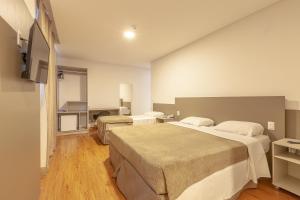 a hotel room with two beds and a television at Tri Hotel São João Batista in São João Batista +25 photos