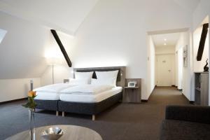 a hotel room with a bed and a table at Hünerbein's Posthotel in Bissendorf in Schledehausen +50 photos