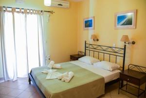 1 dormitorio con 1 cama con toallas en Villagio, en Lefkada