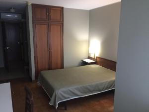 a bedroom with a bed and a dresser at São Roque Hotel & Suites in Bragança