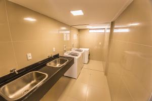 uma casa de banho com um lavatório, um fogão e um WC. em GOLDFLAT - Cabo Branco by PenareiaTurBr em João Pessoa