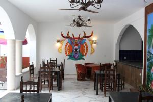 un comedor con mesas y sillas y una pintura en la pared en Hotel Casona Margot en Valladolid