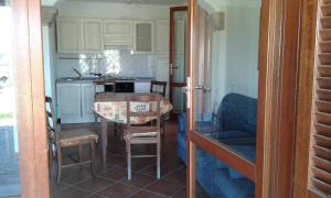 uma cozinha com mesa e cadeiras e uma cozinha com balcão em Sardinia Baya Sant'Anna em Budoni