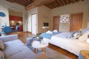 a bedroom with a large bed and a living room at La Tonnellerie in Beaune