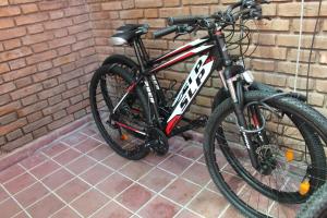 una bicicletta è parcheggiata contro un muro di mattoni di Sentite como en casa a Mendoza