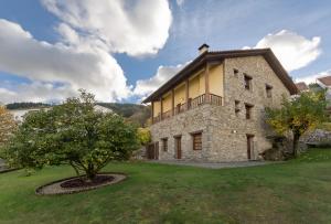 um grande edifício de pedra com uma árvore em frente em SerraVale - House & Nature em Manteigas