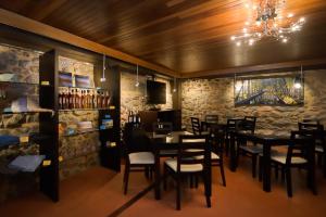 a restaurant with tables and chairs and a stone wall at SerraVale - House & Nature in Manteigas