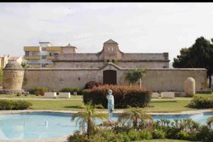 a person standing in front of a large building at SUNNY APARTMENT NEAR THE BEACH. in Rincón de la Victoria