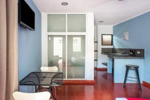 a living room with a glass table and a blue wall at Hotel Dpas 52 in Mérida