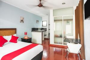 a bedroom with a bed and a desk and a kitchen at Hotel Dpas 52 in Mérida