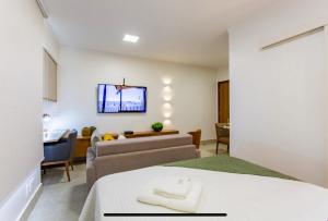 a bedroom with a bed and a living room at Kit Net Studio - II, moderna e aconchegante in Brasilia