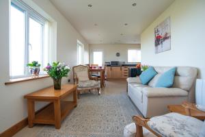 a living room with a couch and a table at Finest Retreats - Sea Views Cottage in Prestatyn