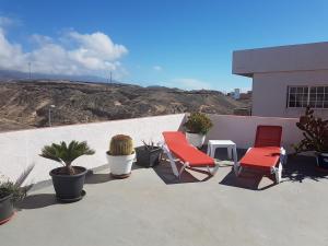 3 sillas y una mesa en un patio con plantas en Casa Rita La Caleta de Arico, en La Mareta