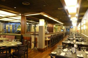 a restaurant with tables and chairs and a bar at Lafayette Hotel in Buenos Aires