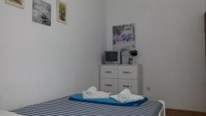 a bedroom with a bed and a tv on a dresser at Apartmani Drašković in Petrovac na Moru