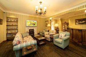 Una sala de estar con sofás y sillas y una chimenea. en Rokeby Manor, en Invergarry