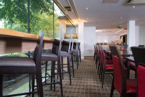 ein Restaurant mit einer Stuhlreihe und einer Bar in der Unterkunft Holiday Inn Express Bath by IHG in Bath