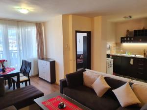 uma sala de estar com um sofá, uma mesa e uma cozinha em Koko's apartments em Bansko