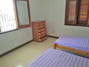 1 Schlafzimmer mit 2 Betten, einer Kommode und einem Spiegel in der Unterkunft Casa Beira-Mar 10pessoas 3 Suítes Térreo - A única realmente "Pé na Areia" c WiFi in Caraguatatuba