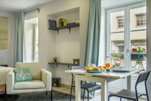 a living room with a table and a chair at BF Suites & Apartments in Porto