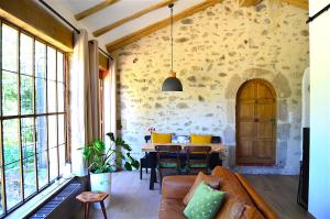 salon z kanapą i stołem w obiekcie Mas Mialou w mieście Saint-Jean-du-Gard