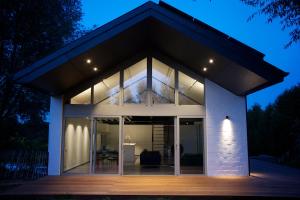 una casa con una gran fachada de cristal por la noche en La Maison Contemporaine, en Namur