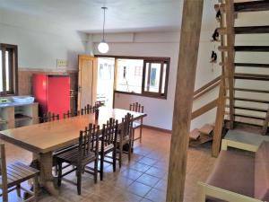 eine Küche und ein Esszimmer mit einem Holztisch und Stühlen in der Unterkunft Casa Beira-Mar 10pessoas 3 Suítes Térreo - A única realmente "Pé na Areia" c WiFi in Caraguatatuba