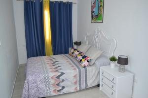Schlafzimmer mit einem Bett und blauen Vorhängen in der Unterkunft Gran Notch in Alicante