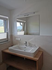een badkamer met een witte wastafel en een spiegel bij Biohof Gölly in Neumarkt in Steiermark