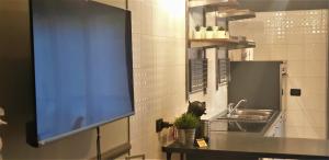 a kitchen with a sink and a tv on the wall at Welcome Brescia Apartments - Volta in Brescia