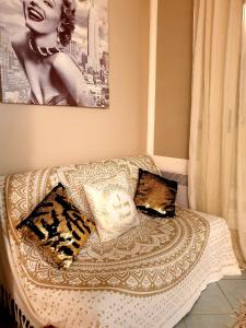 ein Bett mit zwei Kissen und ein Bild einer Frau in der Unterkunft la maison di Angelica in Beausoleil