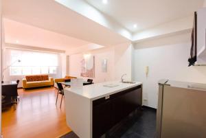 uma cozinha e sala de estar com um lavatório e um sofá em Hotel Aparta Suite Continental Bogotá em Bogotá