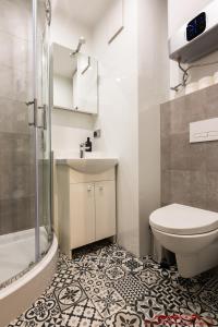 y baño con aseo, lavabo y ducha. en Apartment nearto Old Town Halicka street, en Cracovia