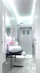 a white bathroom with a sink and a shower at La Casa Del Borgo in Brienza