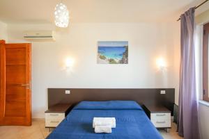 a bedroom with a blue bed with a blue blanket at I Girasoli in Bari Sardo